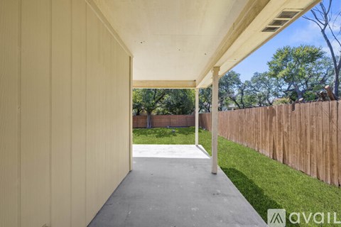 A long, narrow, covered walkway leads from the foreground to a backyard.