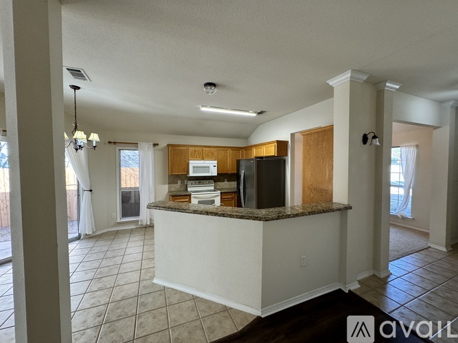 A kitchen with white cabinets and a granite countertop.
