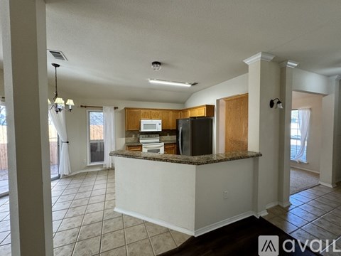 A kitchen with white cabinets and a granite countertop.