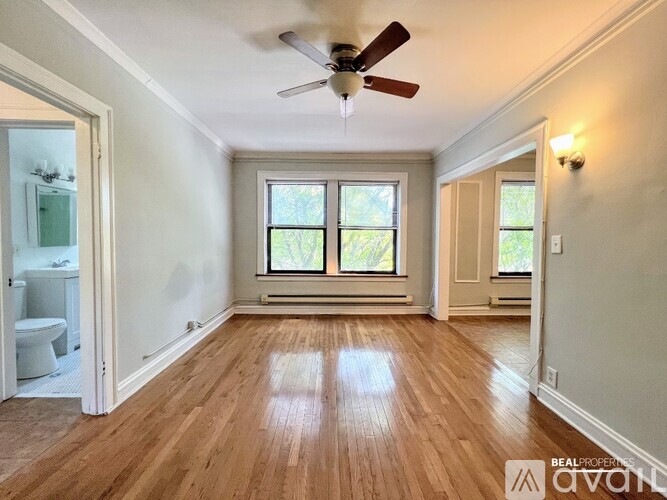A room with wooden floors and a ceiling fan.
