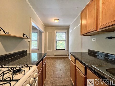 A kitchen with a black countertop and a white stove top.
