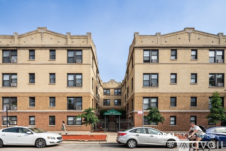 Two identical buildings with cars parked in front.