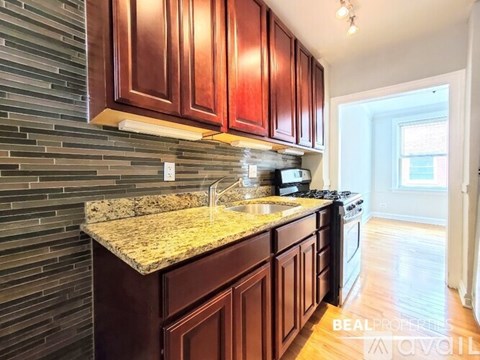 A kitchen with brown cabinets and a granite countertop.