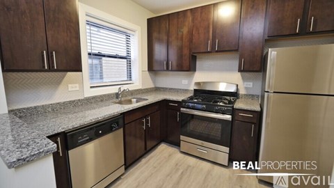 A kitchen with dark wood cabinets and stainless steel appliances.