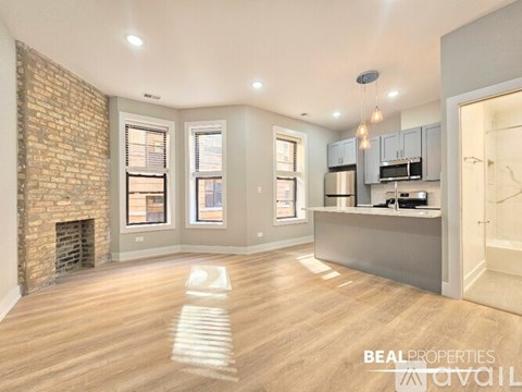 A spacious living room with a brick fireplace and wooden flooring.