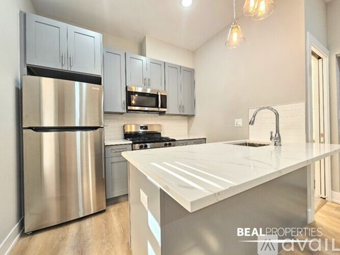 A modern kitchen with a stainless steel refrigerator and a white countertop.