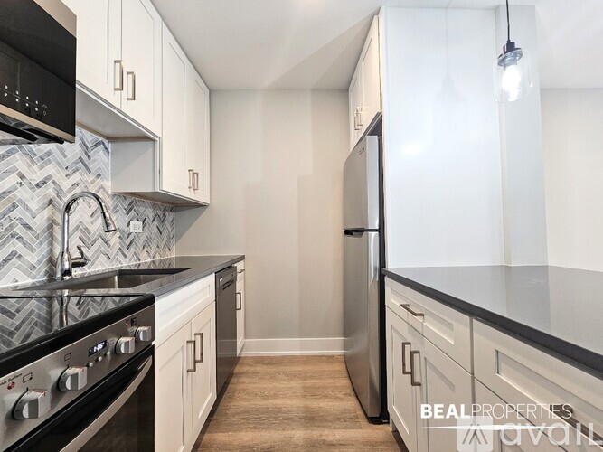 A kitchen with a black stove top oven and a white refrigerator.