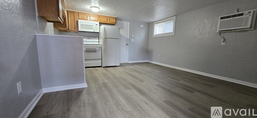 A kitchen area with a white refrigerator and wooden cabinets.