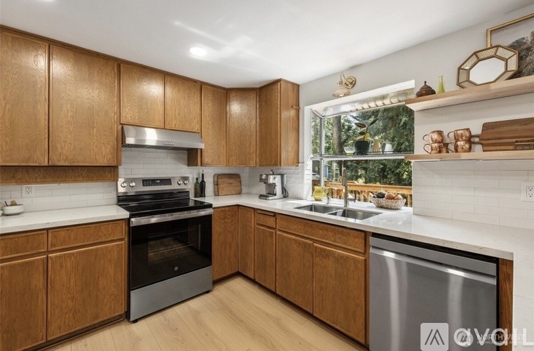 A kitchen with wooden cabinets and a stainless steel dishwasher.