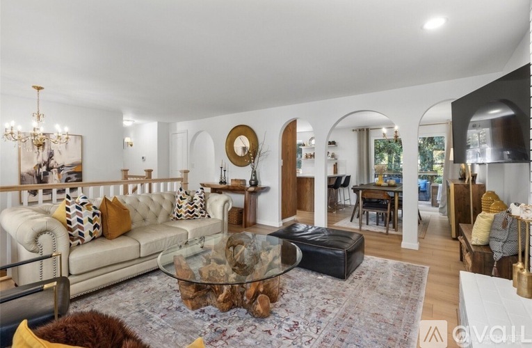 A living room with a white couch and a glass coffee table.