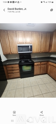 A kitchen with wooden cabinets and a black stove top oven.