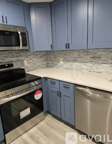 A kitchen with blue cabinets and a stainless steel dishwasher.
