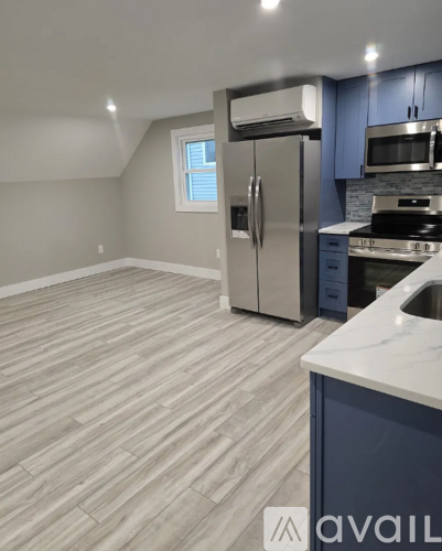 A kitchen with a refrigerator, stove, and cabinets.