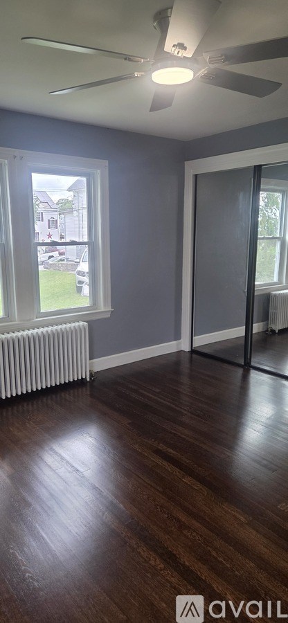 A room with a ceiling fan and a window.