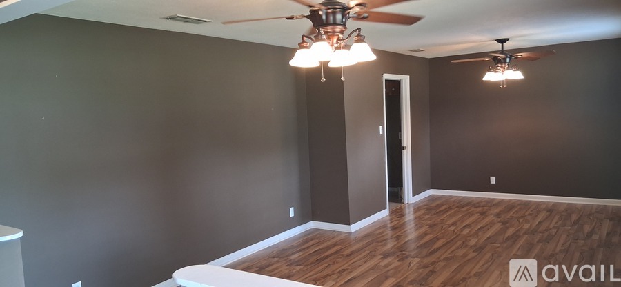 A room with wooden floors and a ceiling fan.
