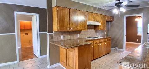 A kitchen with wooden cabinets and a granite countertop.