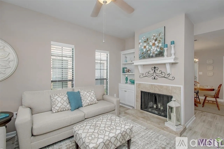 A living room with a couch, a fireplace, and a painting on the wall.