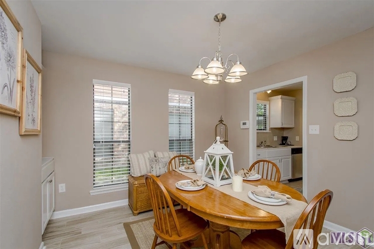 A dining room with a wooden table set for a meal.