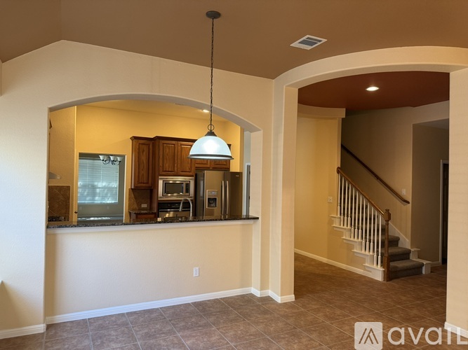 A well-lit kitchen area with a bar counter and cabinets.