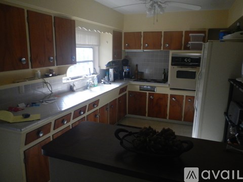 A kitchen with wooden cabinets and a black countertop.