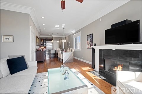 A living room with a fireplace and a television on the wall.