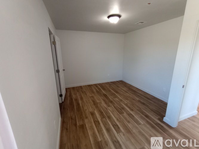 A room with wooden flooring and white walls.