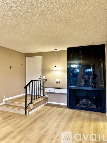 A living room with a staircase and a fireplace.