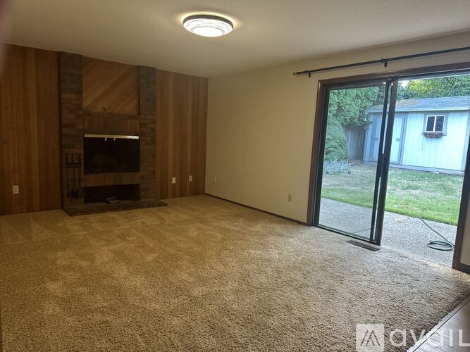 A living room with a fireplace and sliding glass doors.