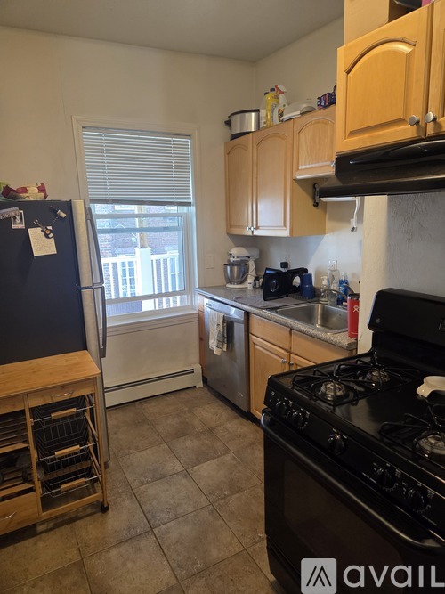 A kitchen with a black stove top oven and a black refrigerator.