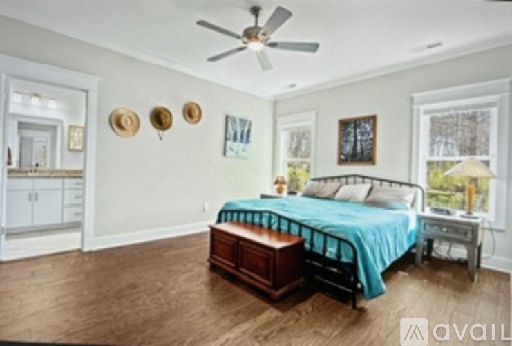 A bedroom with a bed, dresser, and ceiling fan.