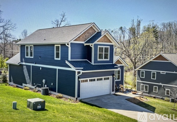 A large house with a blue exterior and a white garage door.
