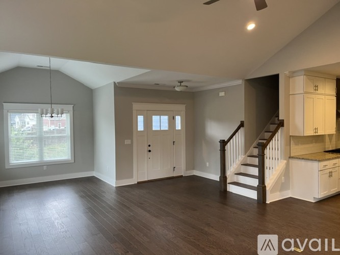 A spacious living room with a staircase leading to the upper floor.