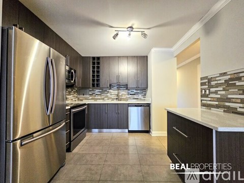 A modern kitchen with a stainless steel refrigerator and a tiled floor.