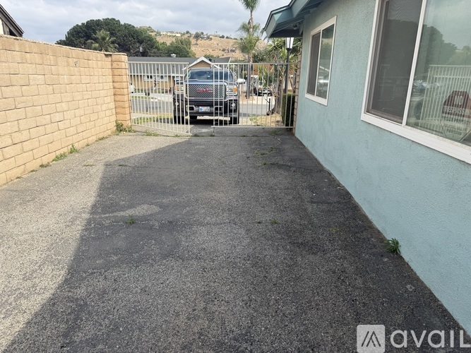A gravel driveway leads to a metal gate.