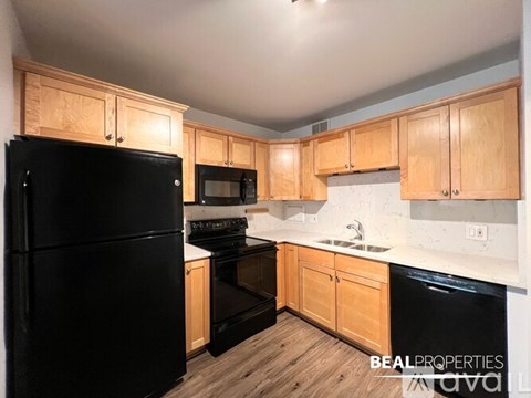 A kitchen with wooden cabinets and black appliances.