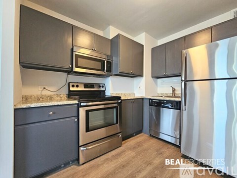 A kitchen with a stove top oven, microwave, and refrigerator.