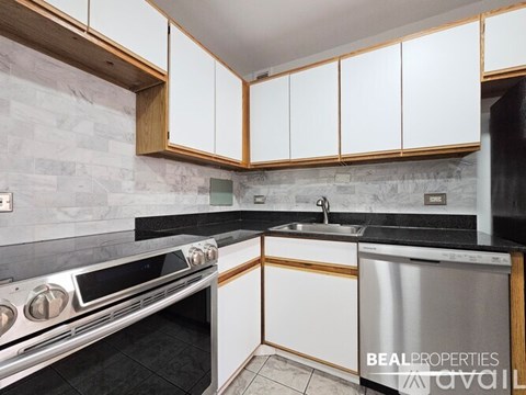 A kitchen with white cabinets and a stainless steel dishwasher.
