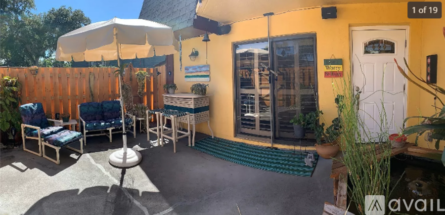 A yellow building with a white door and a sign that says "available" on the right side.