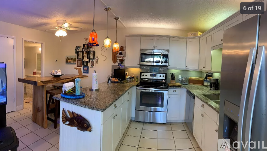 A kitchen with white cabinets and a granite countertop.