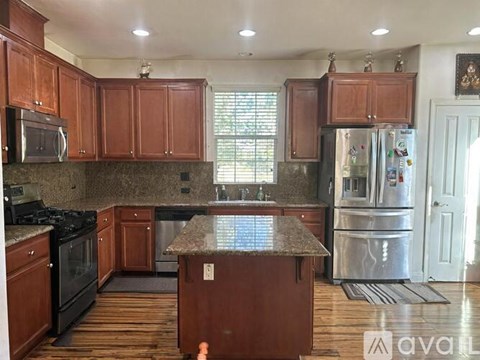 A kitchen with wooden cabinets and a granite countertop.