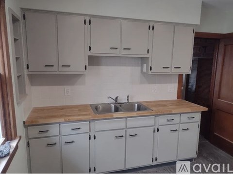 A kitchen with white cabinets and a wooden countertop.