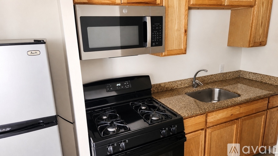A kitchen with a stove, microwave, and oven.
