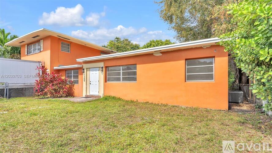 A two-story house with orange walls and a white door.