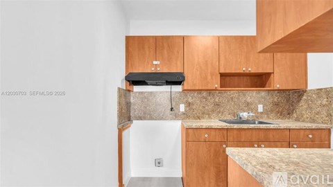 A kitchen with wooden cabinets and a granite countertop.