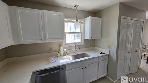 A kitchen with white cabinets and a sink.