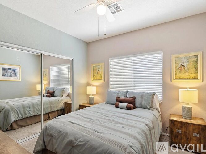 A bedroom with two beds and a ceiling fan.