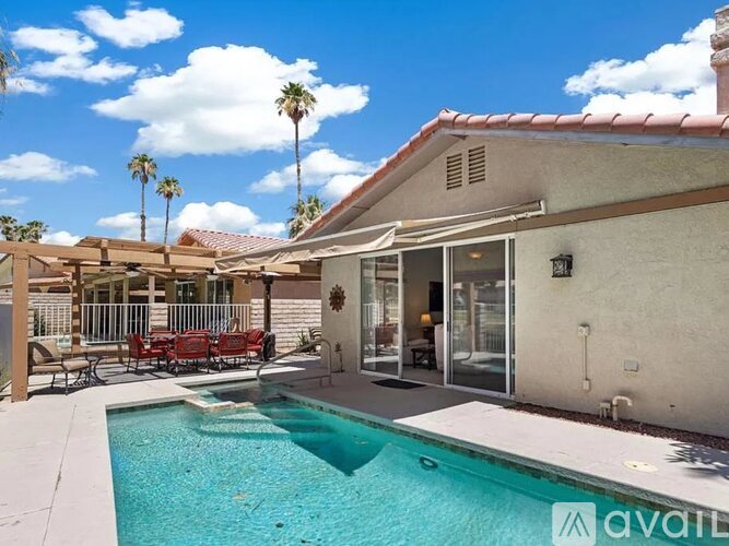 A house with a pool and patio furniture.