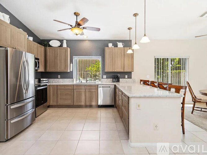 A kitchen with a refrigerator, stove, and sink.