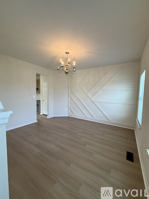 A room with wooden flooring and a chandelier.