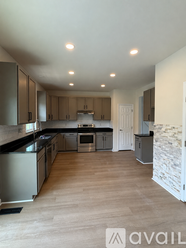 A spacious kitchen with wooden floors and modern appliances.